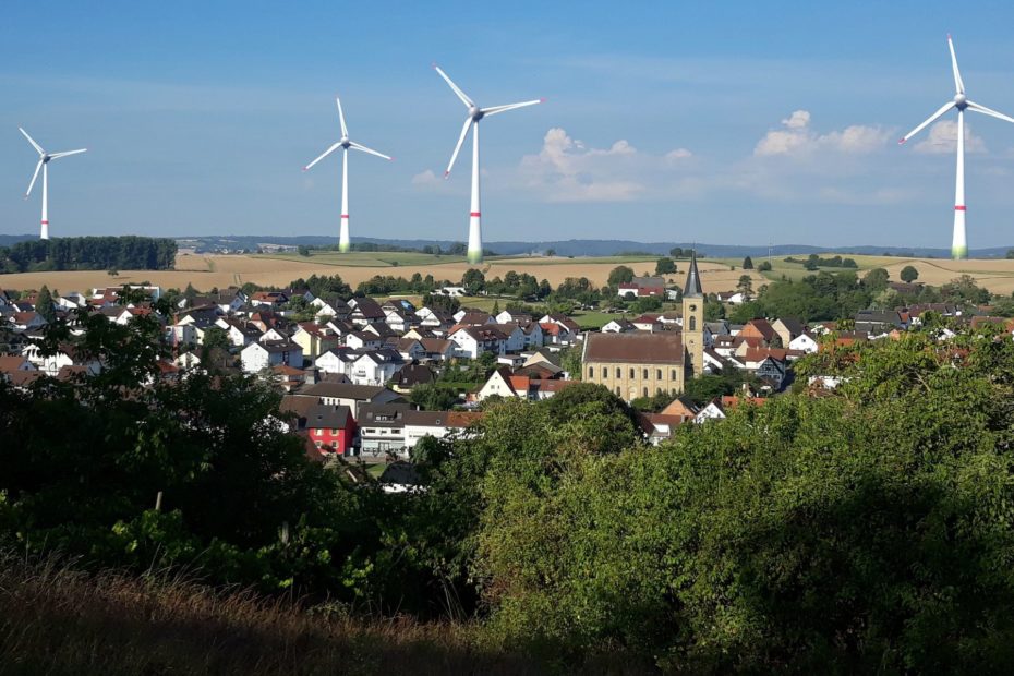 Blick über Menzingen im Hintergrund sind die geplanten Windkraftanlagen maßstabsgetreu dargestellt.